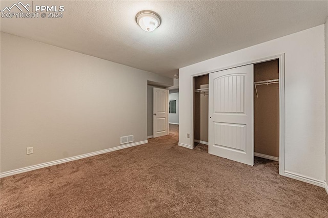 unfurnished bedroom featuring carpet and a closet