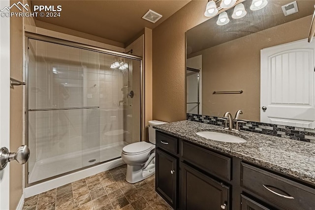 bathroom with tile patterned floors, toilet, walk in shower, and vanity