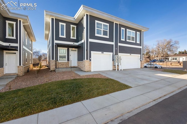 view of front of property featuring a garage and a front lawn