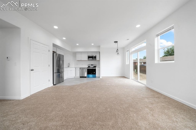 unfurnished living room featuring light colored carpet