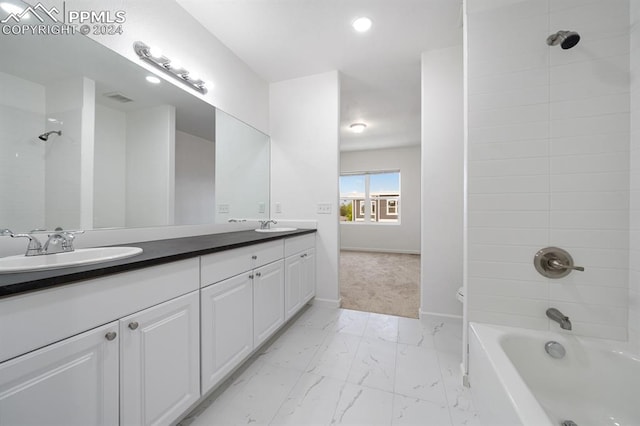 bathroom with tiled shower / bath and vanity