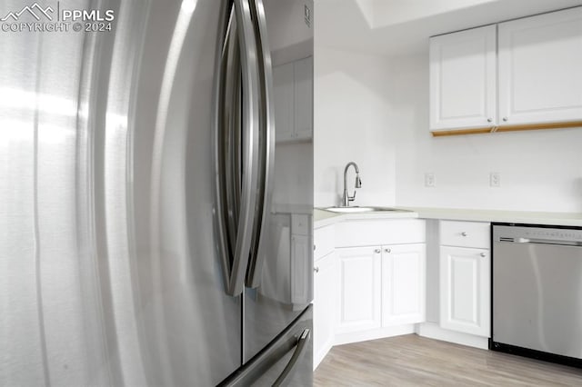 kitchen featuring light hardwood / wood-style flooring, stainless steel appliances, sink, and white cabinetry