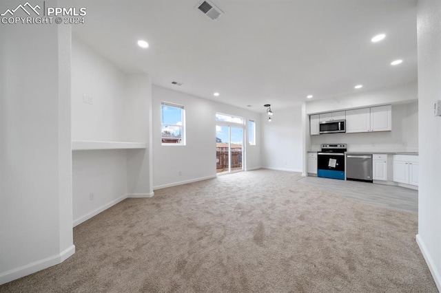 unfurnished living room featuring light carpet