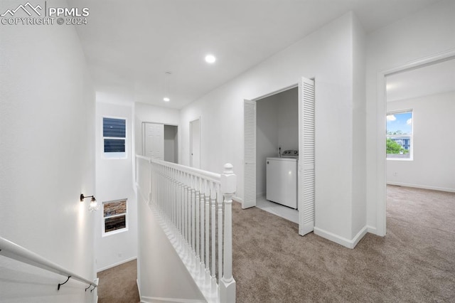 interior space with washer / clothes dryer and light colored carpet