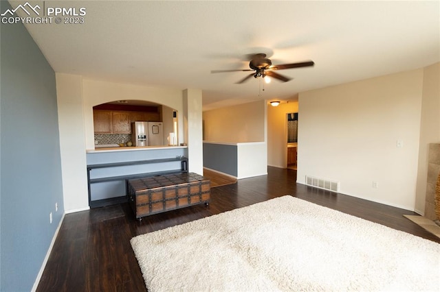 unfurnished living room featuring ceiling fan and dark hardwood / wood-style floors