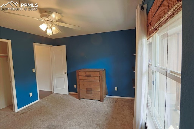 unfurnished bedroom with ceiling fan, a closet, and dark colored carpet