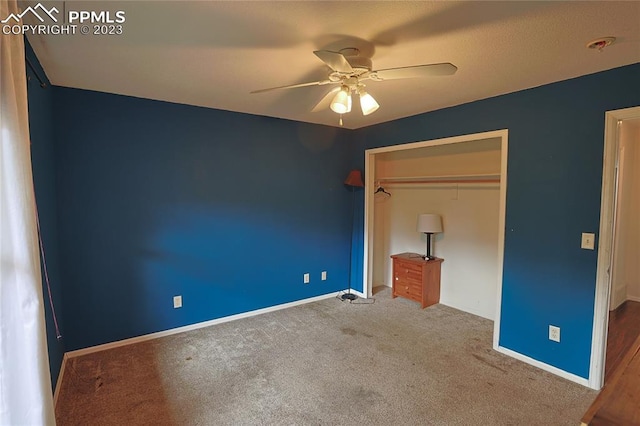 unfurnished bedroom featuring a closet, dark colored carpet, and ceiling fan