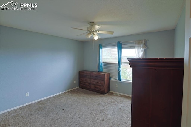 unfurnished bedroom with light colored carpet and ceiling fan