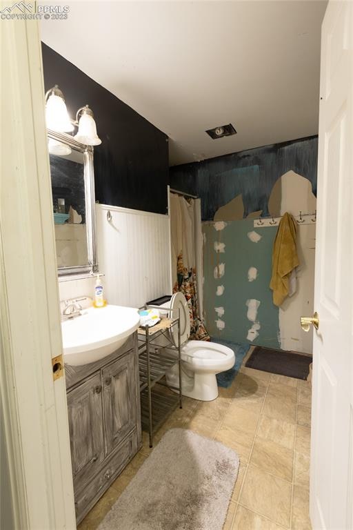 bathroom with toilet, tile floors, and large vanity