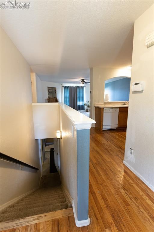 stairway with dark hardwood / wood-style flooring and ceiling fan