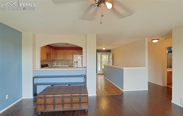 kitchen with dark hardwood / wood-style flooring, ceiling fan, stainless steel refrigerator with ice dispenser, and tasteful backsplash