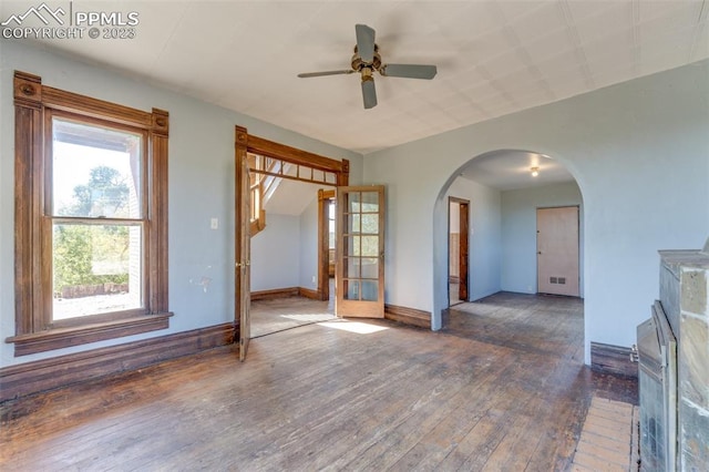 empty room featuring plenty of natural light, dark hardwood / wood-style flooring, and ceiling fan