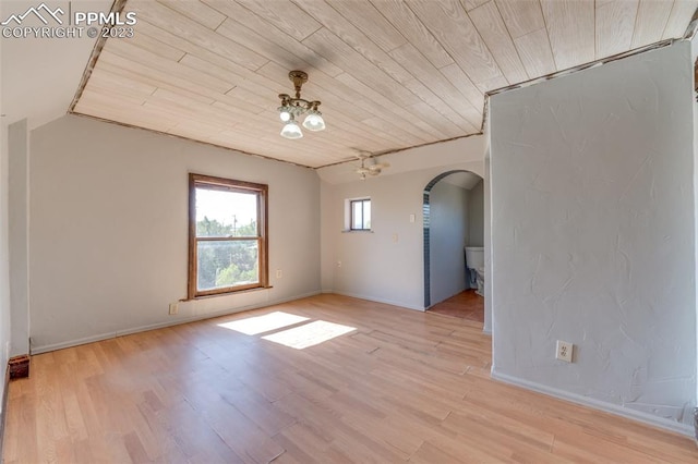 empty room with an inviting chandelier, light hardwood / wood-style floors, and wooden ceiling