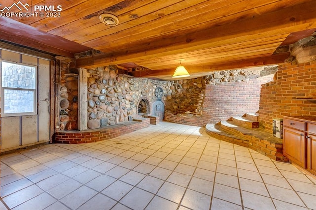 empty room featuring brick wall, beamed ceiling, wood ceiling, and light tile floors