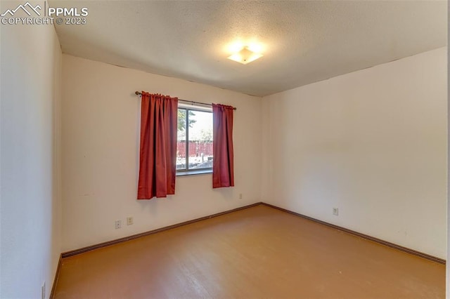 unfurnished room with a textured ceiling