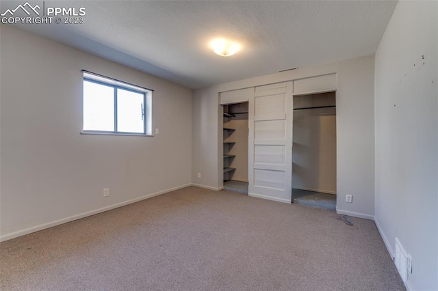 unfurnished bedroom with light carpet and a closet