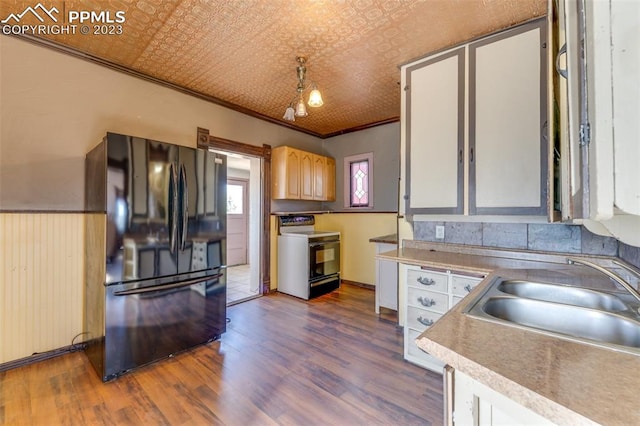 kitchen with dark wood-type flooring, sink, crown molding, black fridge, and stove