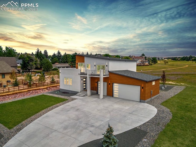 modern home featuring a balcony and a lawn