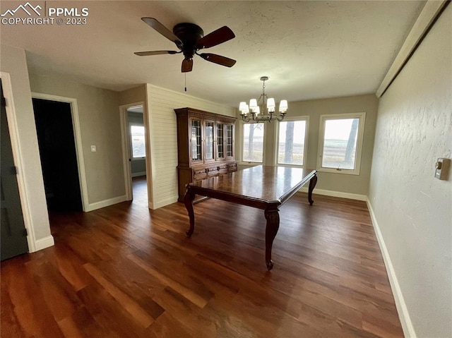 unfurnished dining area with dark hardwood / wood-style floors and ceiling fan with notable chandelier