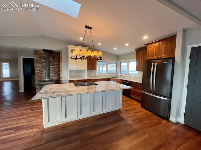 kitchen featuring tasteful backsplash, dark hardwood / wood-style flooring, a kitchen island, hanging light fixtures, and stainless steel refrigerator