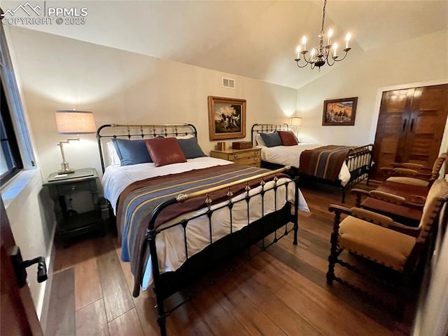 bedroom with a notable chandelier, vaulted ceiling, and hardwood / wood-style flooring