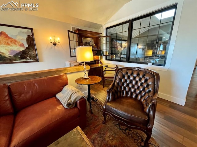 living area with hardwood / wood-style flooring and vaulted ceiling