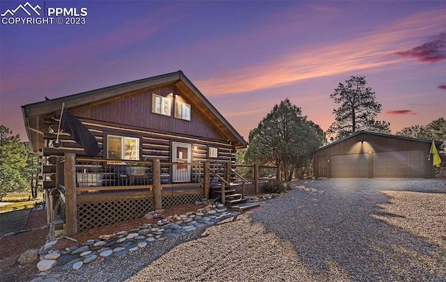 log-style house featuring a deck and a garage