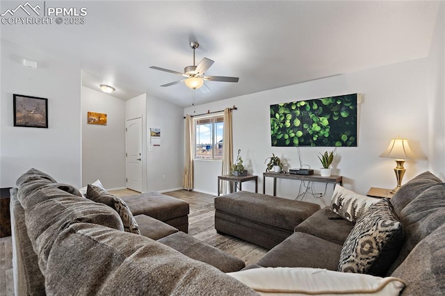 living room with ceiling fan, lofted ceiling, and light hardwood / wood-style floors