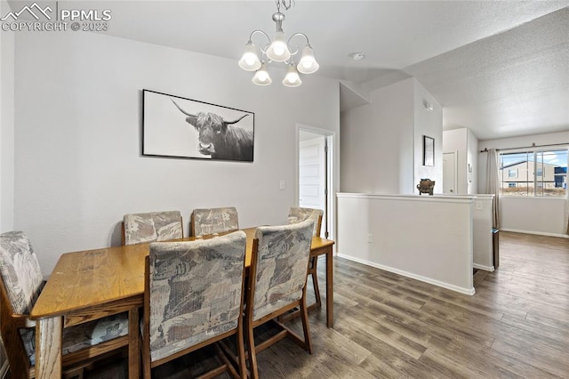 dining space featuring dark hardwood / wood-style floors, an inviting chandelier, and a textured ceiling