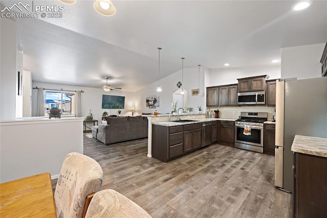 kitchen with appliances with stainless steel finishes, ceiling fan, light hardwood / wood-style flooring, and pendant lighting