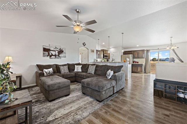 living room with lofted ceiling, dark hardwood / wood-style floors, and ceiling fan with notable chandelier