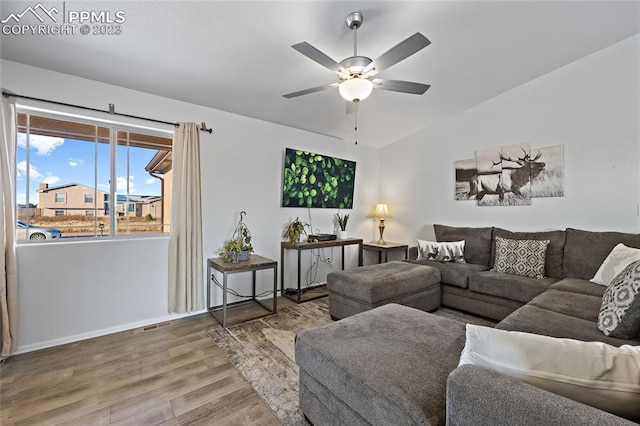 living room featuring lofted ceiling, ceiling fan, and wood-type flooring