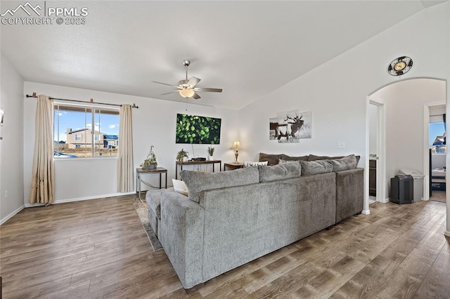 living room with dark hardwood / wood-style flooring, ceiling fan, and lofted ceiling