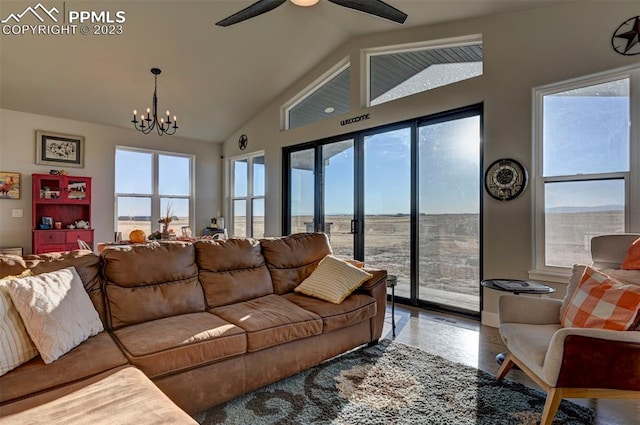 living room featuring lofted ceiling and ceiling fan with notable chandelier