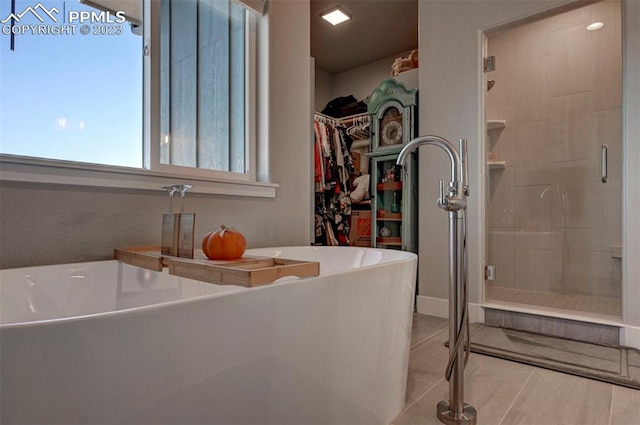 bathroom with tile flooring and plus walk in shower