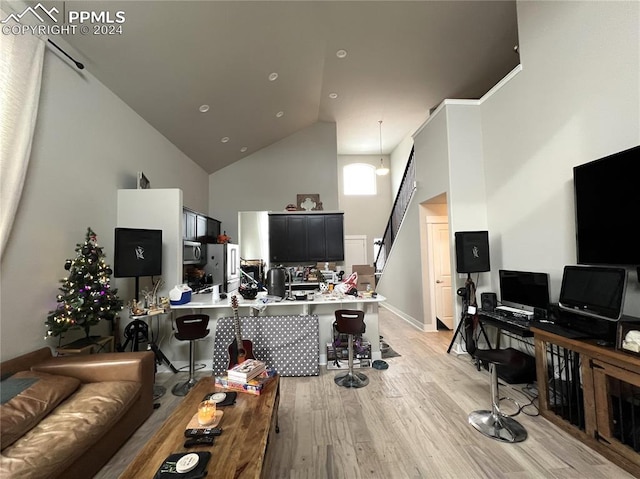 home office featuring high vaulted ceiling and light wood-type flooring