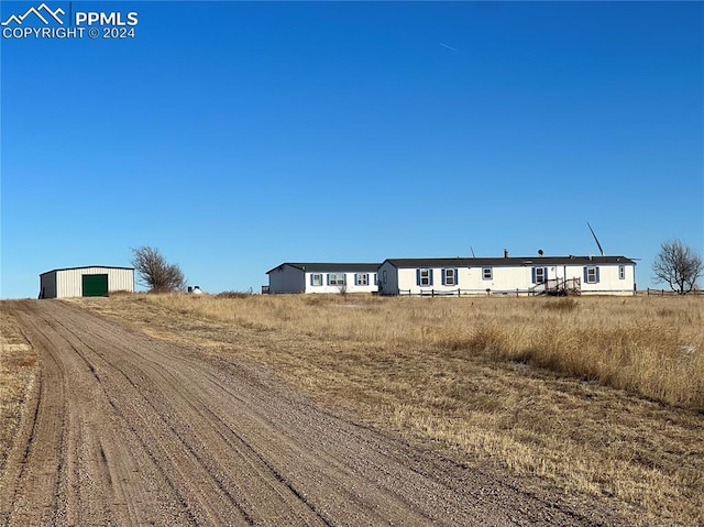 view of street with a pole building, a rural view, and driveway