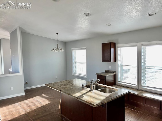 9785 N Calhan Hwy, Calhan, CO 80808 - kitchen with a sink, baseboards, pendant lighting, a textured ceiling, and a kitchen island with sink