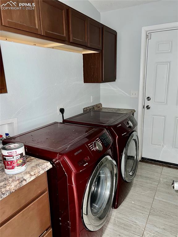 9785 N Calhan Hwy, Calhan, CO 80808 - clothes washing area featuring a garage, cabinet space, and separate washer and dryer