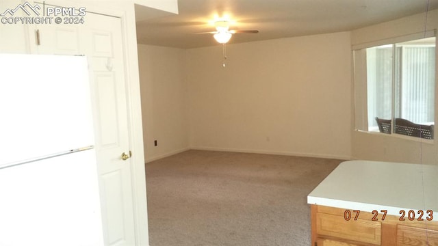 carpeted spare room with ceiling fan