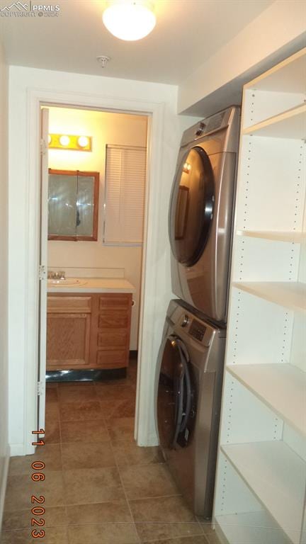 clothes washing area with sink and stacked washer and dryer