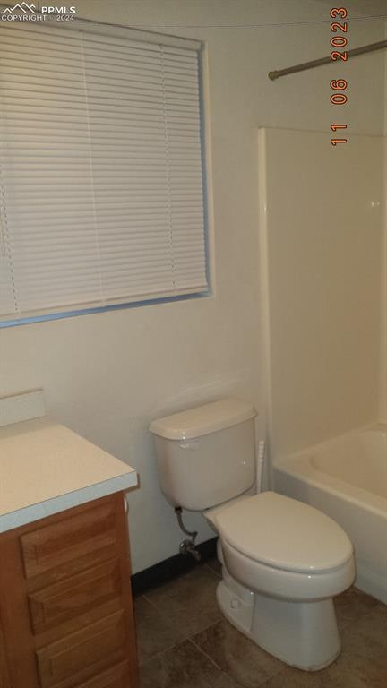 full bathroom featuring vanity, bathing tub / shower combination, toilet, and tile patterned floors