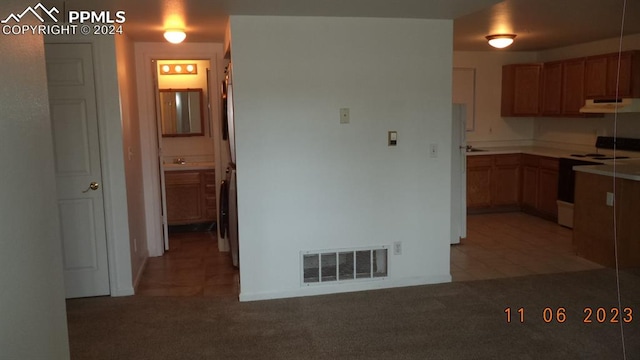 kitchen with washer / clothes dryer, carpet floors, and white range