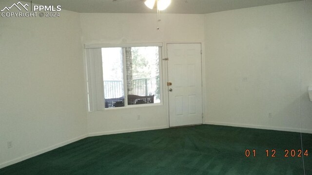 unfurnished room featuring ceiling fan and dark carpet