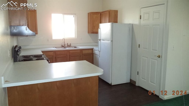 kitchen with kitchen peninsula, sink, stove, white fridge, and dark hardwood / wood-style flooring