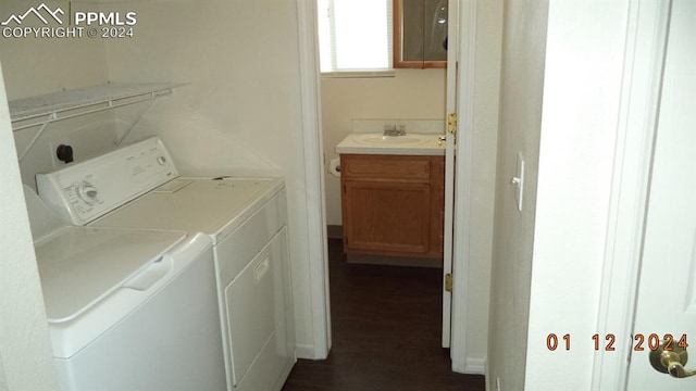 laundry area featuring sink, independent washer and dryer, and dark wood-type flooring