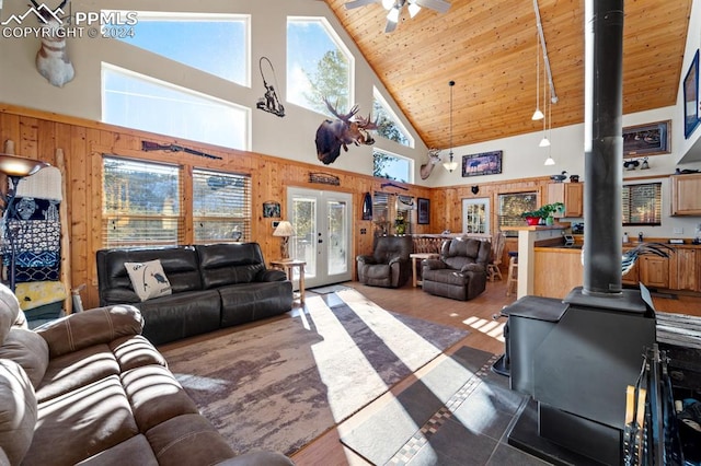 living room with high vaulted ceiling, french doors, ceiling fan, wooden ceiling, and a wood stove