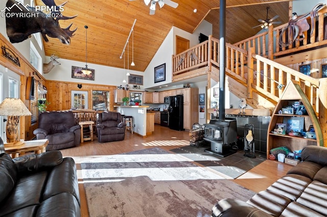 living room featuring ceiling fan, high vaulted ceiling, wood ceiling, hardwood / wood-style floors, and a wood stove