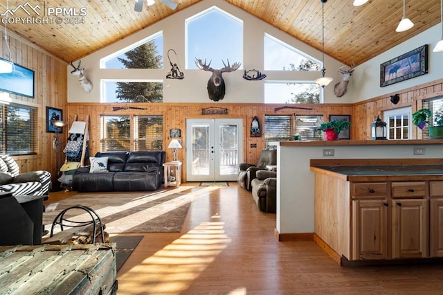 living room featuring high vaulted ceiling, french doors, wooden walls, wooden ceiling, and hardwood / wood-style floors