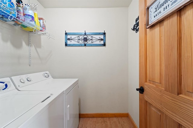 laundry area with light wood-type flooring and separate washer and dryer